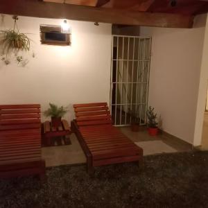 two wooden benches sitting in a room with plants at Finca Ayres de Mis Viejos in Maco