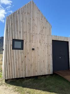 un edificio de madera con puerta y ventana en Cabañas Montañas Patagónicas, en Puerto Natales