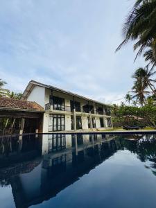 a resort with a pool in front of a building at Villa Nilnara in Ahungalla