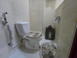 a bathroom with a toilet and a black bag at Vibrant City Haven in the Heart of Kampala in Kampala