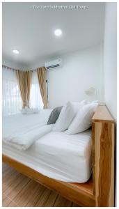 a bedroom with a large bed with white sheets and pillows at The Yard Sukhothai Old Town in Sukhothai