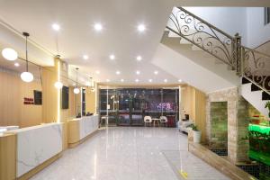 a large lobby with a staircase in a building at Thank You Hotel Sanya Bay Coconut Dream Corridor Branch in Sanya