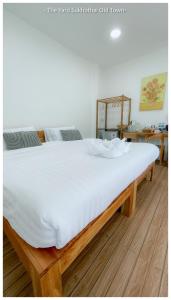 a large white bed in a room with a wooden floor at The Yard Sukhothai Old Town in Sukhothai +39 photos