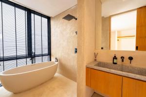 a bathroom with a large white tub and a sink at Villa Thre in Mantaak +21 photos