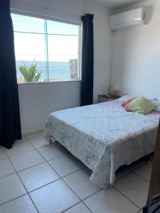 a bedroom with a bed and a large window at Comfort and good memories, right by the lagoon! in São Pedro da Aldeia