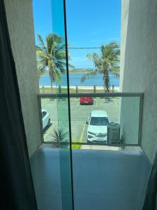 a balcony with a view of a car parked in a parking lot at Comfort and good memories, right by the lagoon! in São Pedro da Aldeia