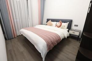 a bedroom with a large bed with white blankets and pillows at Xiaowo SmileNest Downtown Scenic Spot Ticket Service Close to Tianmen Mountain Scenic Area Ideal for Couples, Families and Group Bookings in Zhangjiajie
