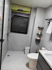 a small bathroom with a toilet and a window at Xiaowo SmileNest Downtown Scenic Spot Ticket Service Close to Tianmen Mountain Scenic Area Ideal for Couples, Families and Group Bookings in Zhangjiajie