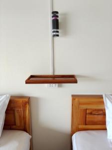 two beds in a room with a light on the wall at DODAND Studio & Sunset Riverside Guesthouse in Don Det +14 photos
