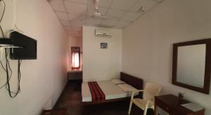 a small room with a small bed and a window at Ayu Kataragama in Kataragama +25 photos