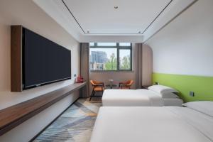 une chambre d'hôtel avec deux lits et une télévision à écran plat dans l'établissement 上海艾菲花园酒店The Garden F, à Shanghai