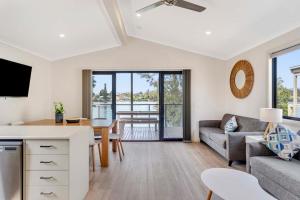 una sala de estar con un sofá y una mesa en Moruya Holiday Park, en Moruya