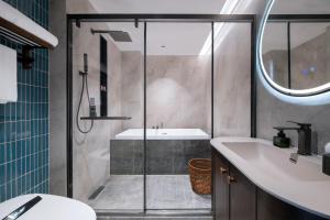 une salle de bain avec douche et lavabo dans l'établissement 上海艾菲花园酒店The Garden F, à Shanghai 25 autres photos