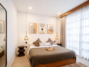 a bedroom with a large bed and a large window at Tribeca Duplex Canggu in Canggu