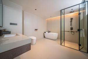 een badkamer met een bad, een wastafel en een douche bij Mehood Lestie in Jinghong +39 foto's