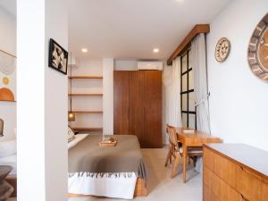 a bedroom with a bed and a desk and a table at Tribeca Duplex Canggu in Canggu