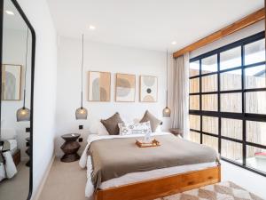 a bedroom with a large bed and a large window at Tribeca Duplex Canggu in Canggu