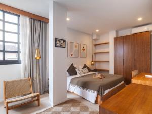 a bedroom with a bed and a desk and a chair at Tribeca Duplex Canggu in Canggu
