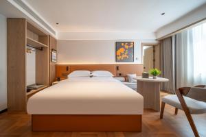 een slaapkamer met een groot bed en een bureau bij Mehood Lestie in Jinghong