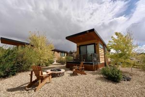 a small cabin with a table and chairs in the yard at Escalante Escapes Holly Hock- King Escape in Escalante