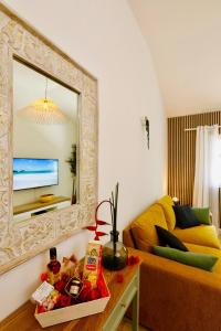 ein Wohnzimmer mit Spiegel und Couch in der Unterkunft Appartement La Perle - Village Creole in Lazaret