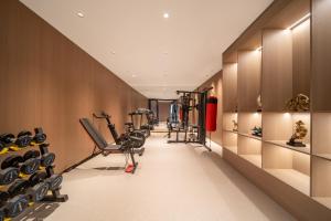 een sportschool met loopbanden en apparaten in een kamer bij Mehood Lestie in Jinghong