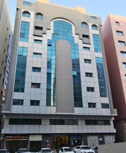 a large building with cars parked in front of it at Sheeva Backpacker Hostel in Abu Dhabi