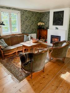 a living room with a couch and chairs and a fireplace at Historic 19Th Century Cottage In Blekinge in Kyrkhult