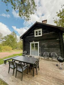 a picnic table in front of a log cabin at Historic 19Th Century Cottage In Blekinge in Kyrkhult
