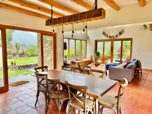 a living room with a wooden table and chairs at Flor de Amancay Villas - Sacred Valley in Calca