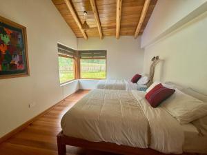 a bedroom with a large bed and a window at Flor de Amancay Villas - Sacred Valley in Calca