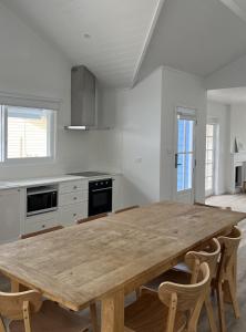 a large kitchen with a wooden table and chairs at Bluebell Huskisson in Huskisson