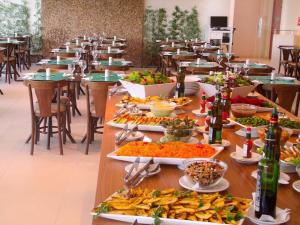 a long table with many plates of food on it at Alugueasy - Hotel Fusion in Brasilia