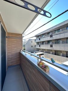 un balcon avec vue sur un immeuble dans l'établissement nestay house tokyo shinjuku, à Tokyo