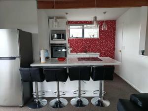 a kitchen with a white counter and black appliances at Spacious City Apartment With Amazing Views in Christchurch