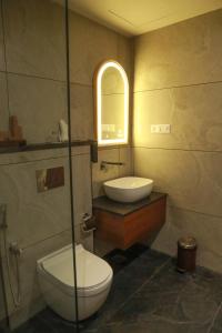 une salle de bain avec toilettes, lavabo et miroir dans l'établissement PASSIONS HOTEL EDATHUA - Alappuzha, à Champakulam