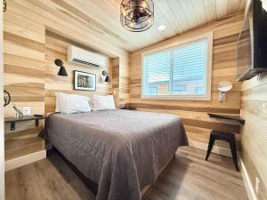 a bedroom with a bed in a room with wooden walls at Escalante Escapes Moon Lily- Bunk Escape in Escalante