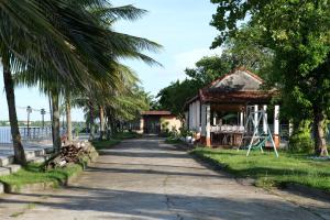 a street with a building and palm trees next to a road at Chang Chang Cozy Home in Kon Rung (1)