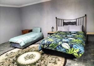 a bedroom with two beds and a rug at Midvaal Guesthouse in Meyerton