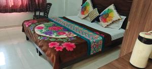 a bed with a colorful quilt on top of it at Hotel Raj Palace in Kumbhalgarh