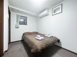 une chambre avec un lit avec deux serviettes dessus dans l'établissement nestay house tokyo shinjuku, à Tokyo 76 autres photos