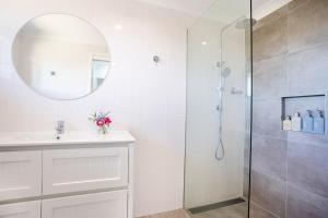 Un baño con ducha, lavabo y espejo. en Kinka's Gem, en Kinka 12 fotos más