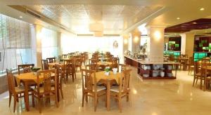 a restaurant with wooden tables and chairs in a room at Au Lac 2 Hotel in Ho Chi Minh City