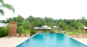 a swimming pool in the middle of a resort at Monn Phu Phrai in Ban Pong