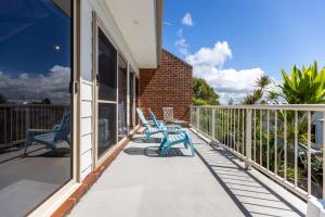 een balkon met twee blauwe stoelen op een huis bij Angourie BAY Villa - Unit 1 in Yamba