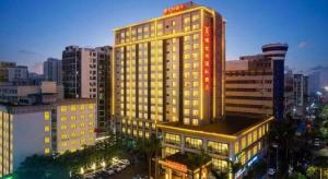 a lit up building in a city at night at Exchange Bank Hotel Hainan in Haikou