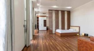 a bedroom with a bed and a wooden floor at Hoang Hung Hotel in Hanoi