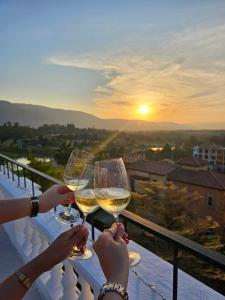 two people holding glasses of white wine on a balcony at Villa Primo Eyrie Khaoyai near Toscana in Ban Bung Toei