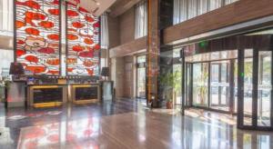 a lobby with a large mural in a building at The Prosperous City Hotel Weifang in Weifang