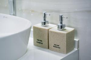 two soap dispensers sitting next to a toilet in a bathroom at White House Hotel in Dồng Văn +107 photos